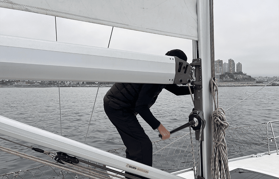Tripulante operando el line driver con manivela en el Mare Nostrum durante el despliegue con viento fuerte