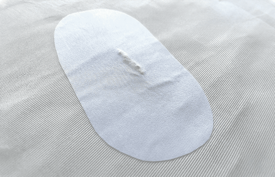 Reparación provisional de una vela con tela autoadhesiva.