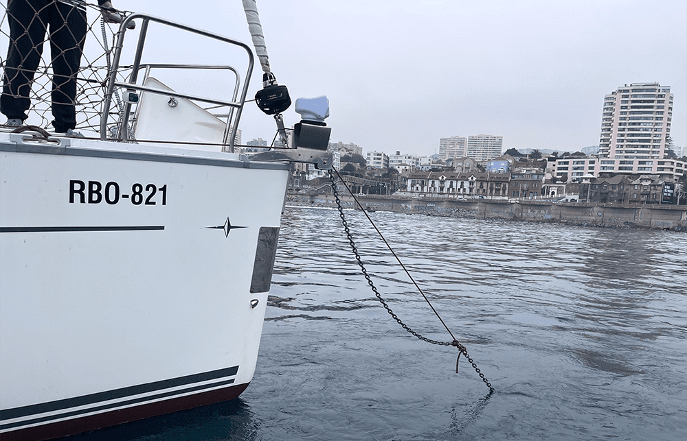 Boza de cabo rojo instalada en la proa del Mare Nostrum RBO-821, con cadena de fondeo visible descendiendo al agua