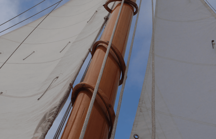 Aros de madera abrazando un mástil de madera en velero clásico, vista en contrapicado