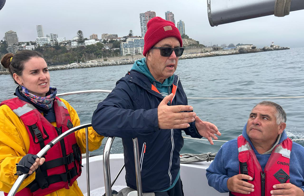 Un capitán del Club explica una maniobra a un alumno a bordo
